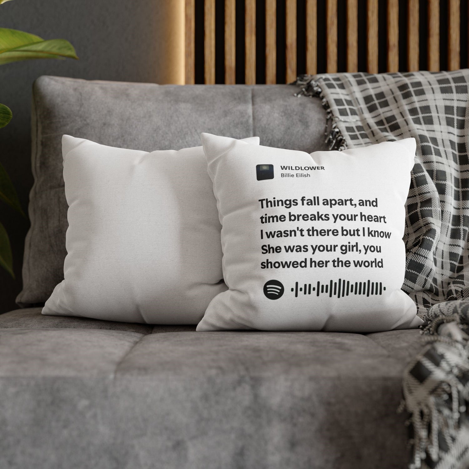 White pillow with text and music notes on a gray couch